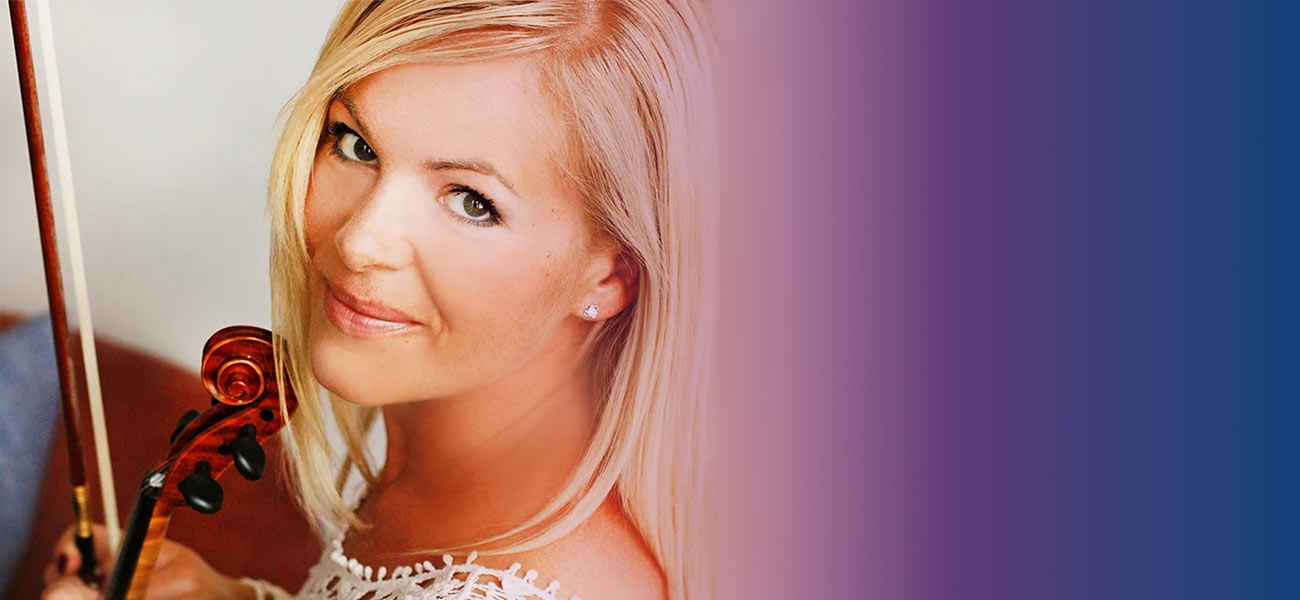 Frau hält Geige und lächelt in die Kamera