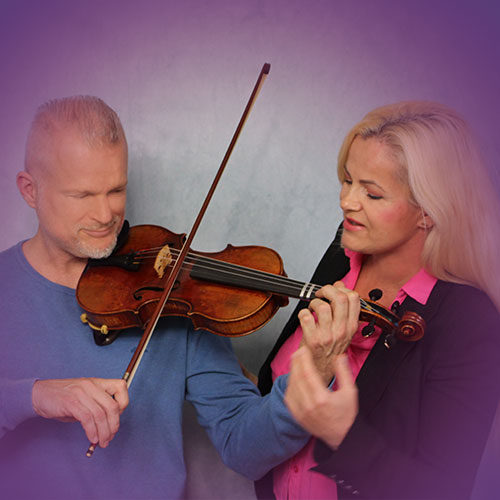 Mann spielt Geige, Frau hört aufmerksam zu