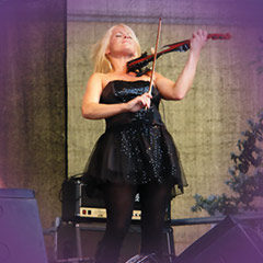 Geigerin spielt auf einer Bühne im Freien