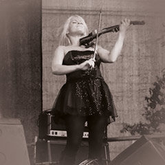 Geigerin spielt auf einer Bühne leidenschaftlich Violine