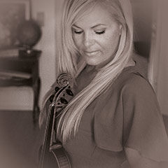 Frau hält Geige in einem Zimmer